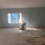 Getting the subfloor ready — sanding smooth for a flawless finish.