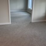 Light grey wall-to-wall carpet in an empty residential room, freshly installed u2013 Warwick Interiors, Invermere BC.